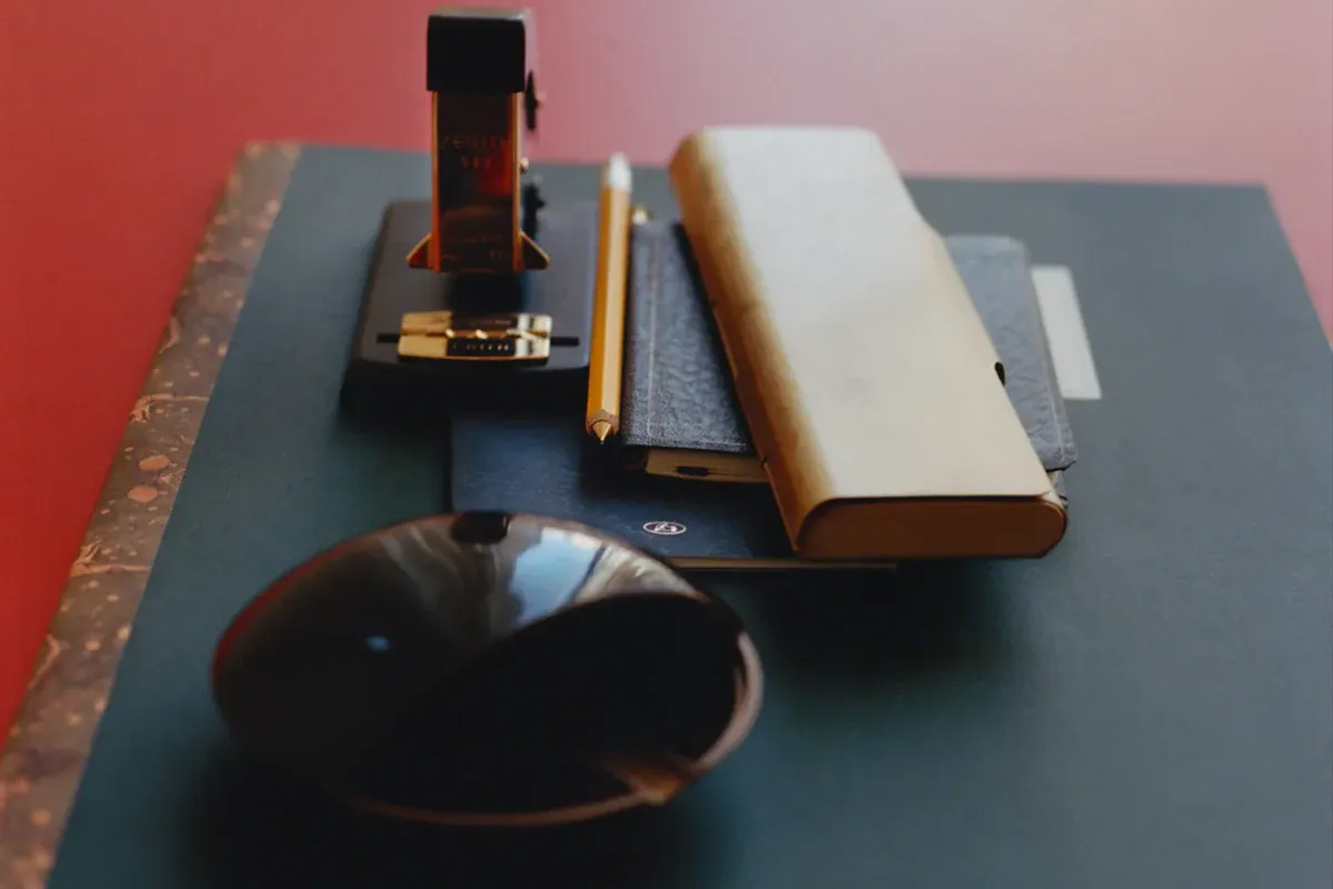 Notebooks and stationery arranged on a dark desk.
